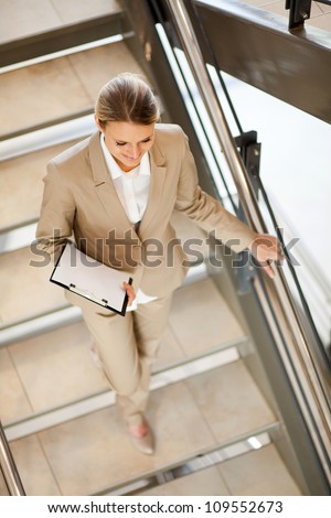 attractive young businesswoman walking down stairs