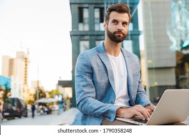 Attractive Young Bussiness Man Working On Laptop Computer While Sitting Outdoors