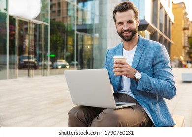 Attractive Young Bussiness Man Working On Laptop Computer While Sitting Outdoors