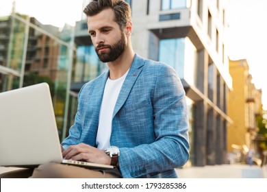 Attractive Young Bussiness Man Working On Laptop Computer While Sitting Outdoors