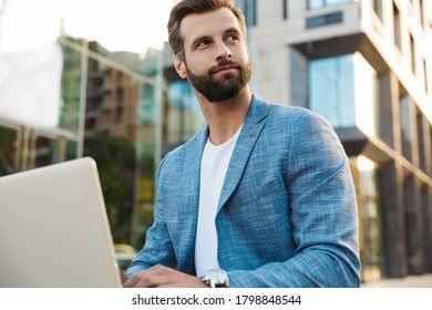 Attractive Young Bussiness Man Working On Laptop Computer While Sitting Outdoors