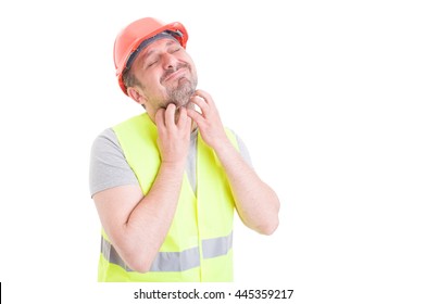 Attractive Young Constructor In Protection Equipment Having Itchy On Beard Isolated On White Background With Advertising Area