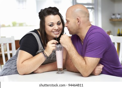 Attractive young couple flirting while drinking milkshake - Powered by Shutterstock