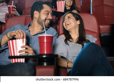 Attractive young couple having fun and enjoying the movie during a date at the cinema theater