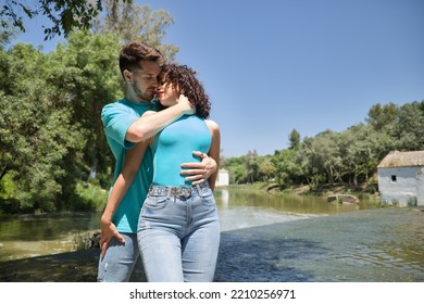 Attractive Young Couple In Love, Looking Into Each Other's Eyes, Close Faces About To Kiss, In Very Sensual Attitude, Next To A River. Concept Love, Passion, Desire, Lovers, Valentine's Day.