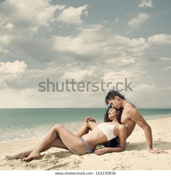 A pair of cute tanned Asian babes relax while sunbathing nude