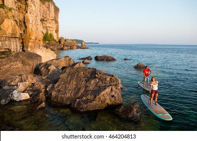 Attractive Young Couple Stand Up Paddle Boarding, Active Beach Lifestyle