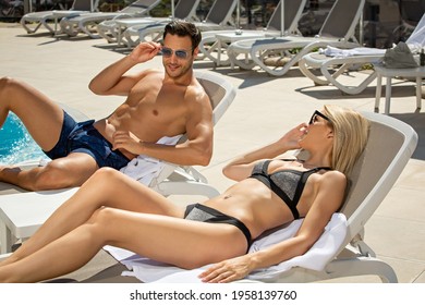 Attractive young couple in swimsuit at hotel swimming pool