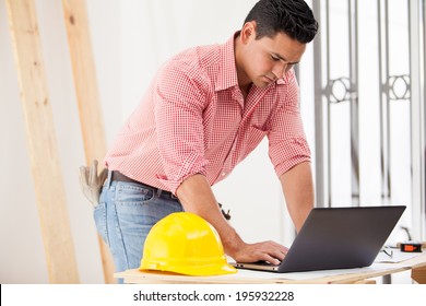 Attractive Young Engineer Doing Some Construction Work And Using A Laptop On Site