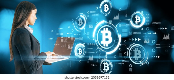 Attractive young european businesswoman using laptop with abstract bitcoin hologram on blurry blue bokeh background. Cryptocurrency, finance and blockchain concept. Double exposure - Powered by Shutterstock