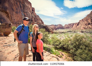 Attractive young family looking out at a beautiful scenic view in a red rock canyon in the Southwest United States - Powered by Shutterstock