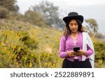 Attractive young farmer woman answers video call outdoors, smart girl communicates enthusiastically in online conference outdoors, emotional farmer woman talking about recording content