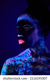 Attractive Young Female Model In Bright Blacklight Bodyart, Chamring Calm Female In Mindful, Peaceful, Stand Looking At Side, Posing At Camera. Body Art, Fantastic, Fluorescent, Luminescence