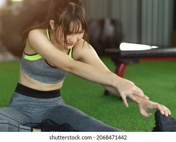 Attractive Young Fit Woman Cool Down After Workout, Exercise Stretching Her Leg At The Fitness Gym.