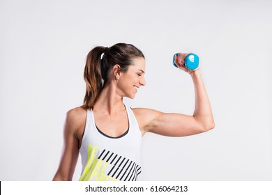 Attractive Young Fitness Woman Holding Dumbell. Studio Shot.