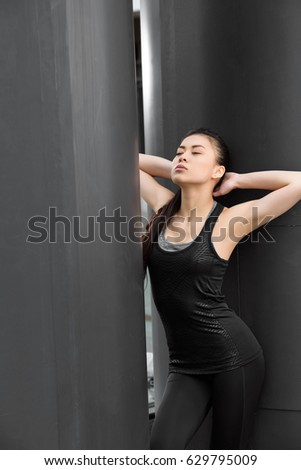 Attractive young fitness woman in sportswear posing on stadium  