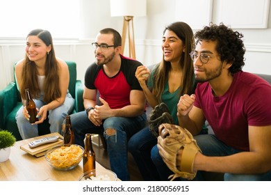 Attractive Young Friends Smiling And Laughing While Watching The Baseball Game On Tv