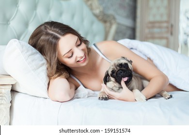 Attractive Young Girl With Dog While Laying On A Bed