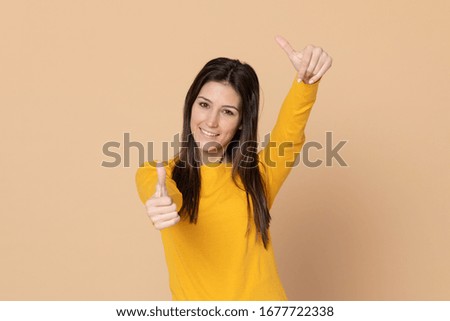Attractive young girl wearing a T-shirt on a yellow background