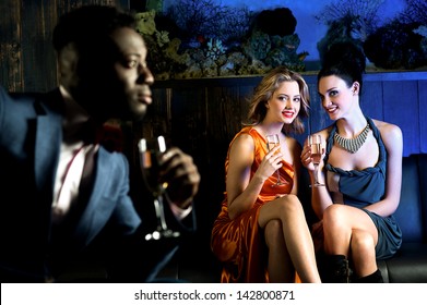 Attractive Young Girls Staring At Handsome Young Man In Night Club.