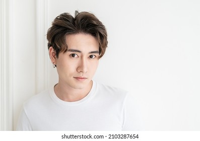 Attractive young handsome smiling face positive asian, korean happy casual man, stay home minimal lifestyle. Closeup portrait of asia middle age 20s man wearing white shirt in studio. Young model boy 