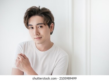 Attraktive junge gut lächelnde Gesicht positiven asiatischen, koreanischen glücklichen flüchtigen Mann, bleiben zu Hause minimalen Lebensstil. Nahaufnahme eines asiatischen 20er-Jährigen mit weißem Hemd im Studio. Jungmodellbote 