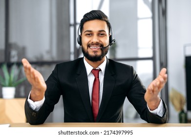 Attractive Young Indian Or Arabian Businessman, Financial Advisor, Sit At Desk In Modern Office, Having Video Call Conversation With Client, Male Economic Expert Records Online Training Course, Smile