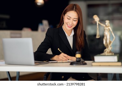 Attractive young lawyer in office Business woman and lawyers discussing contract papers with brass scale on wooden desk in office. Law, legal services, advice, Justice and real estate concept. - Shutterstock ID 2139798281