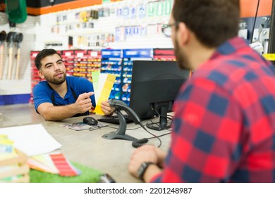 Attractive Young Man Asking For The Paint Color Swatches To A Male Employee At The Hardware Store 