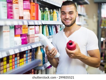 Attractive Young Man Buying Shampoo In Shopping Mall