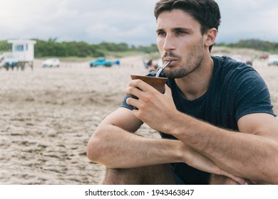 Attractive young man drinking yerba mate, herbal tea.