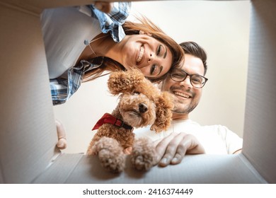 Attractive young man with eyeglasses together with beautiful smiling woman and cute poodle dog looking inside open box with belongings while relocating in new place. - Powered by Shutterstock
