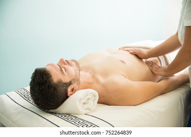 Attractive young man getting an abdominal massage from a therapist in a health spa