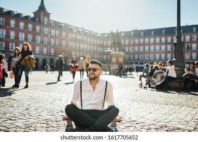 Attractive Young Man Influencer.Tourist Visiting Famous Landmarks And Places.Cheerful Male Traveler At Famous Plaza Mayor Square, Site Seeing Attractions.Vacation In Spain, Blogger Lifestyle