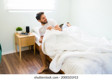 Attractive Young Man Leaving The Bed After Having Sex With A Sleeping Young Woman In A One Night Stand