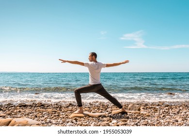 Attractive young man practicing yoga meditation and breathwork outdoors by the sea - Powered by Shutterstock