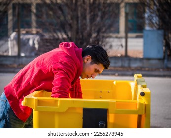 Attractive young man putting out rubbish standing