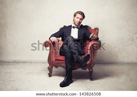 attractive young man sitting on an armchair