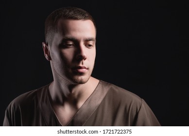 Attractive Young Man In Standing With A Pensive Look On A Dark Background. Studio Photography