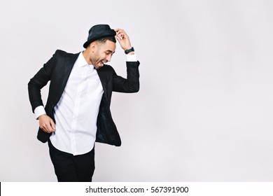 Attractive Young Man In Suit Dancing, Having Fun On White Background. Stylish Outlook, Hat, Successful Businessman, Happy, Expressing True Positive Emotions, Funny. Place For Text