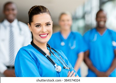 attractive young medical doctor and colleagues in hospital - Shutterstock ID 384574024