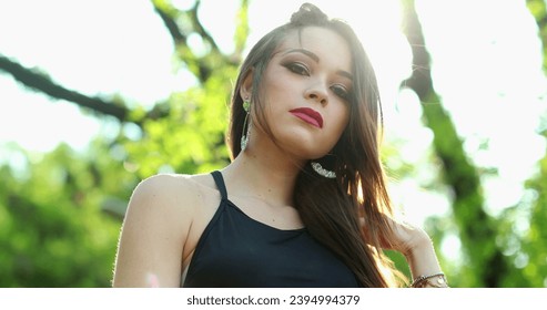 Attractive young millennial woman posing looking to camera with lens-flare sunlight in outdoor park - Shutterstock ID 2394994379