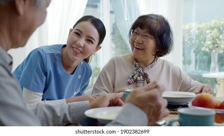 Attractive young senior asian citizen couple happy sit, talk, eat soup for healthy nutrition breakfast meal on dining table at home in morning in routine lifestyle in old asia nursing in-home care.