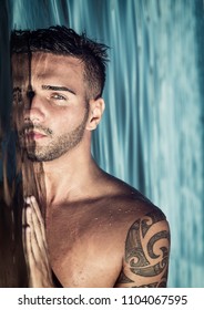 Attractive Young Shirtless Athletic Man Standing In Water In Sea Or Lake, With Half Face Submerged Underwater, Looking At Camera