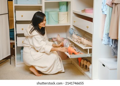 Attractive Young Woman In Bathrobe Choosing Shoes In Dressing Room At Home