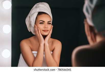 Attractive Young Woman In Bathroom After Shower Is Standing In Front Of Mirror. Women Care.