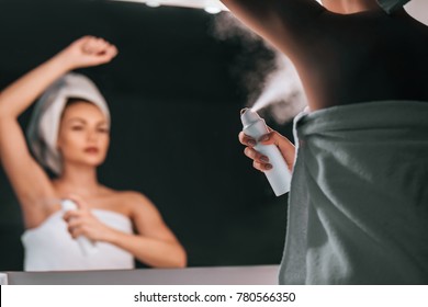 Attractive Young Woman In Bathroom After Shower Is Standing In Front Of Mirror With Deodorant In Hands. Women Care.