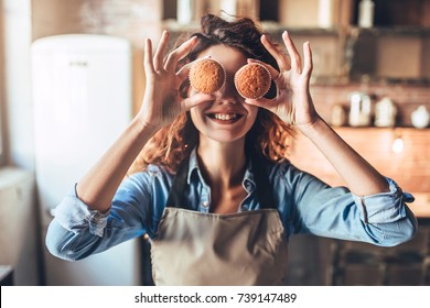 Attractive young woman is cooking on kitchen. Having fun while making cakes and cookies.