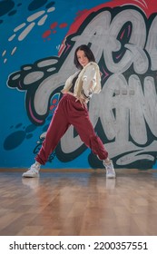 Attractive Young Woman Doing Breakdance Move Over Graffiti Background