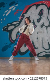 Attractive Young Woman Doing Breakdance Move Over Graffiti Background